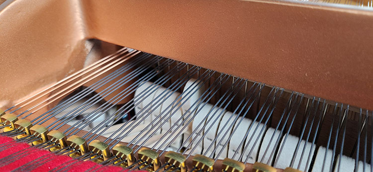 yamaha gc2 hammer hitting the string. showing the agraffes and strings