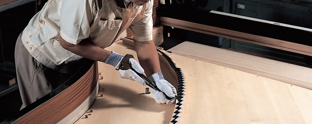 Master craftsman working on the Yamaha CF4 European spruce soundboard